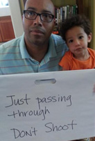 Photo of Chris Lebron holding sign "Don't Shoot"